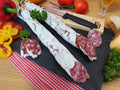 Angeschnittene Salami auf einer Schieferplatte