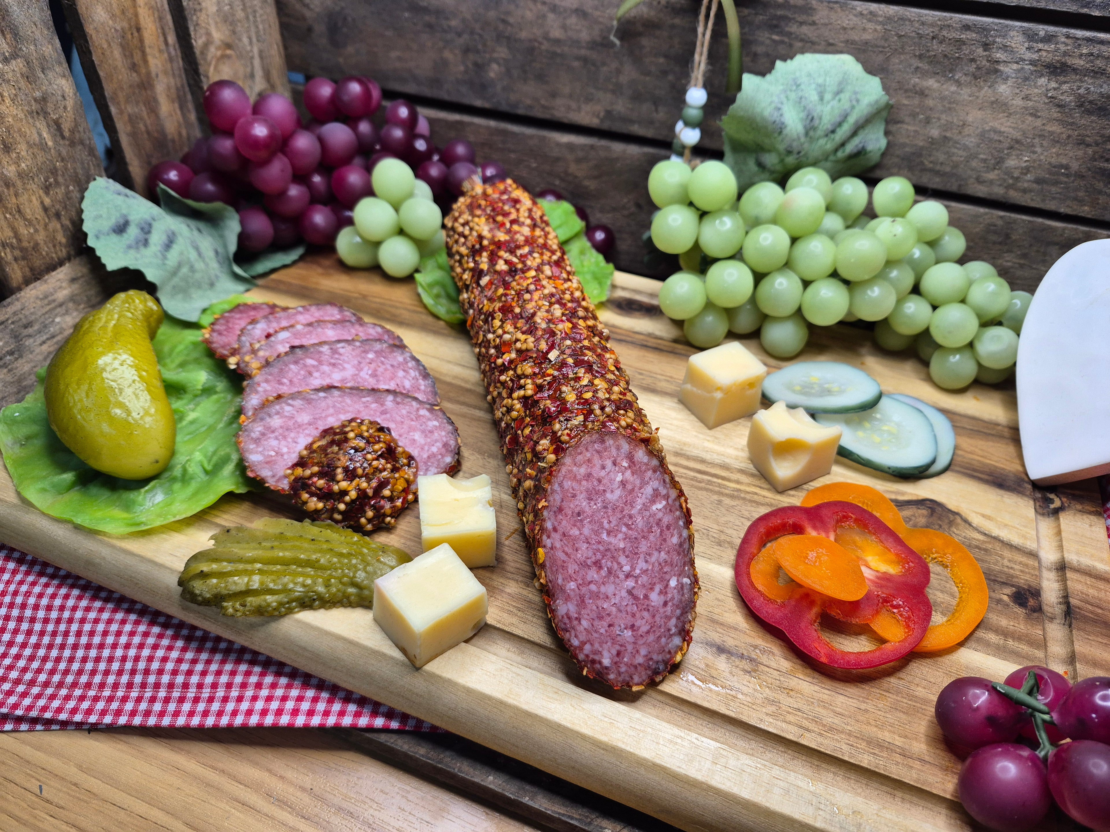 Salami mit Gewürz-Rand auf Holzbrett mit Trauben dekoriert